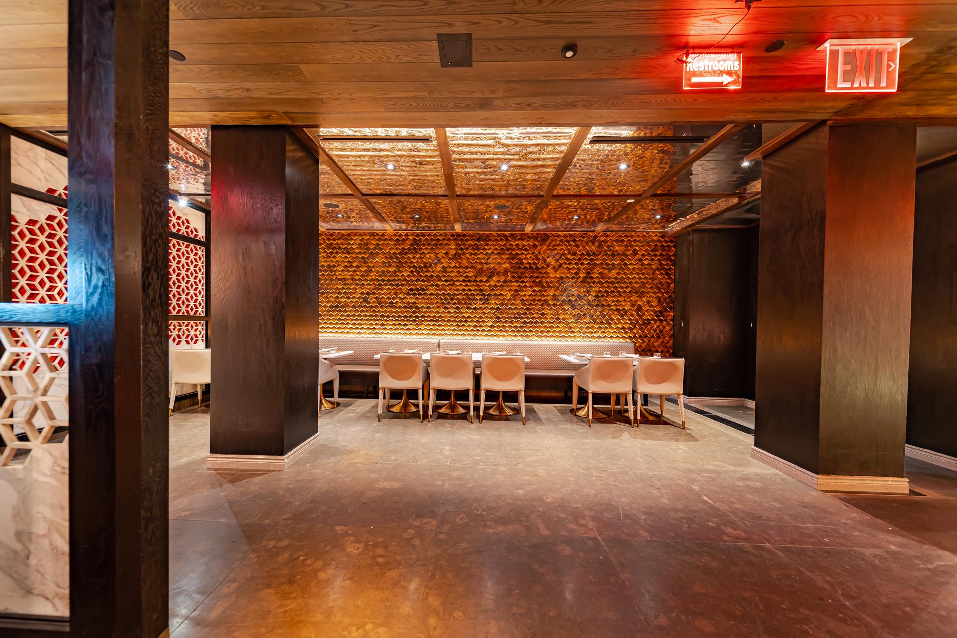 An open room at Fushimi Times Square with a wood-slat ceiling, a warm-lit wall and a row of tables and chairs