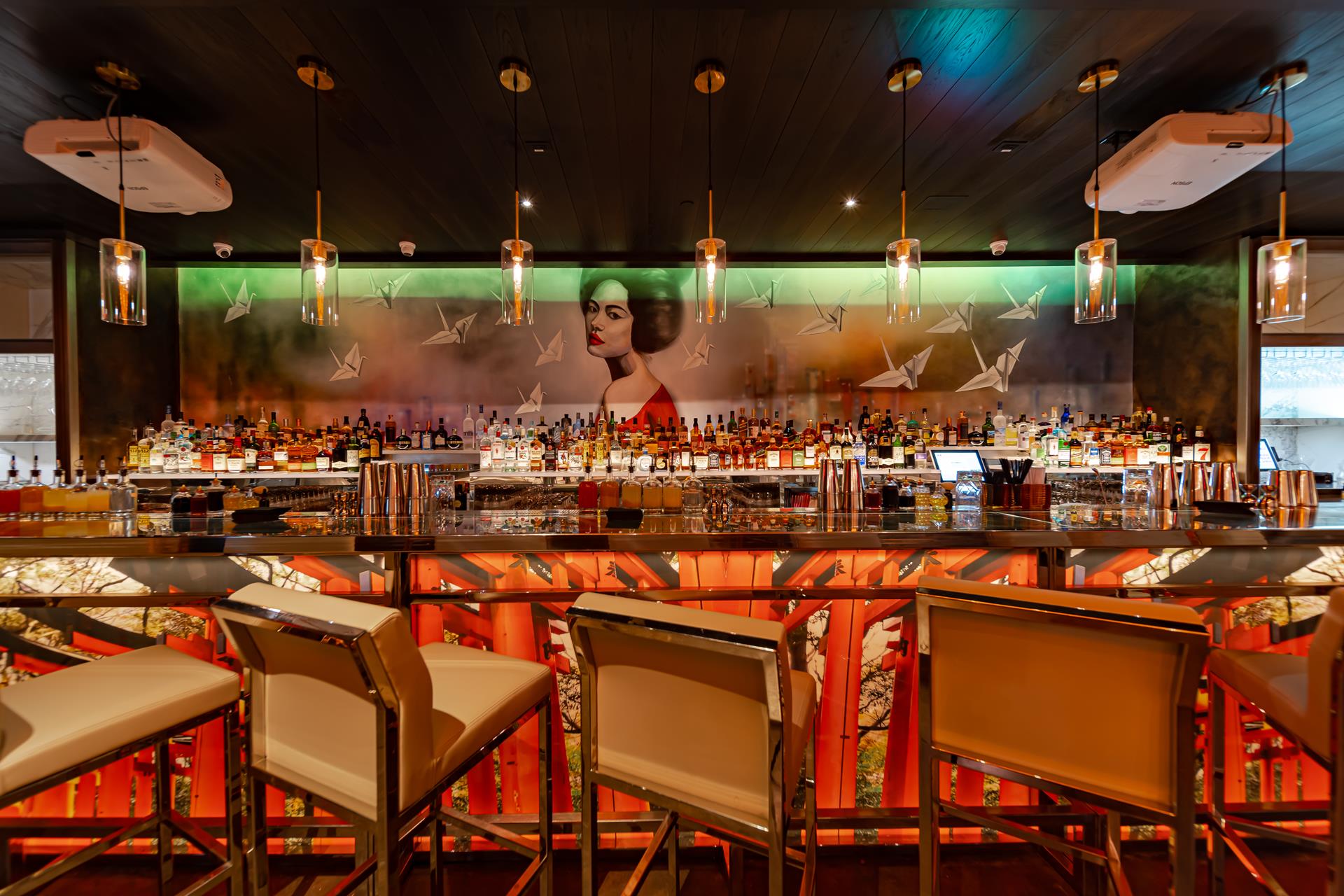 The bar and lounge at Fushimi Times Square, with high-backed bar stools, pendant lights and a large mural above the back bar