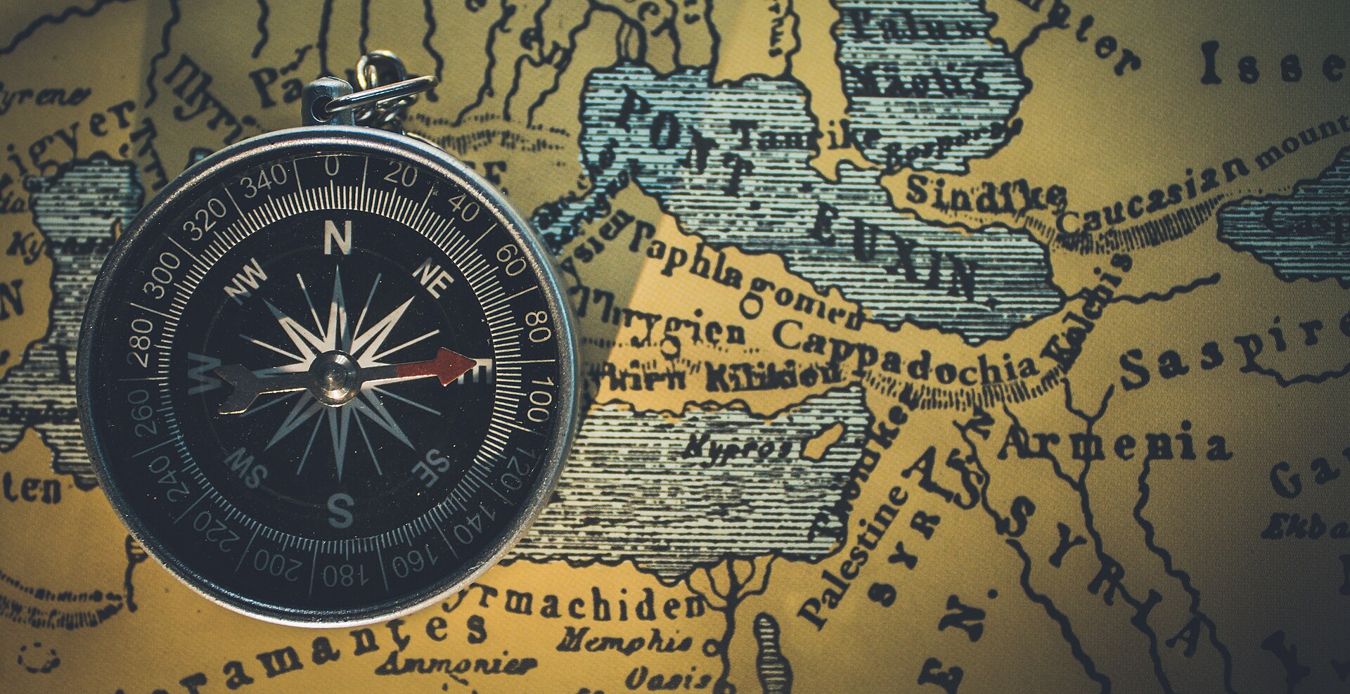 A compass resting on an old map, pointing the way