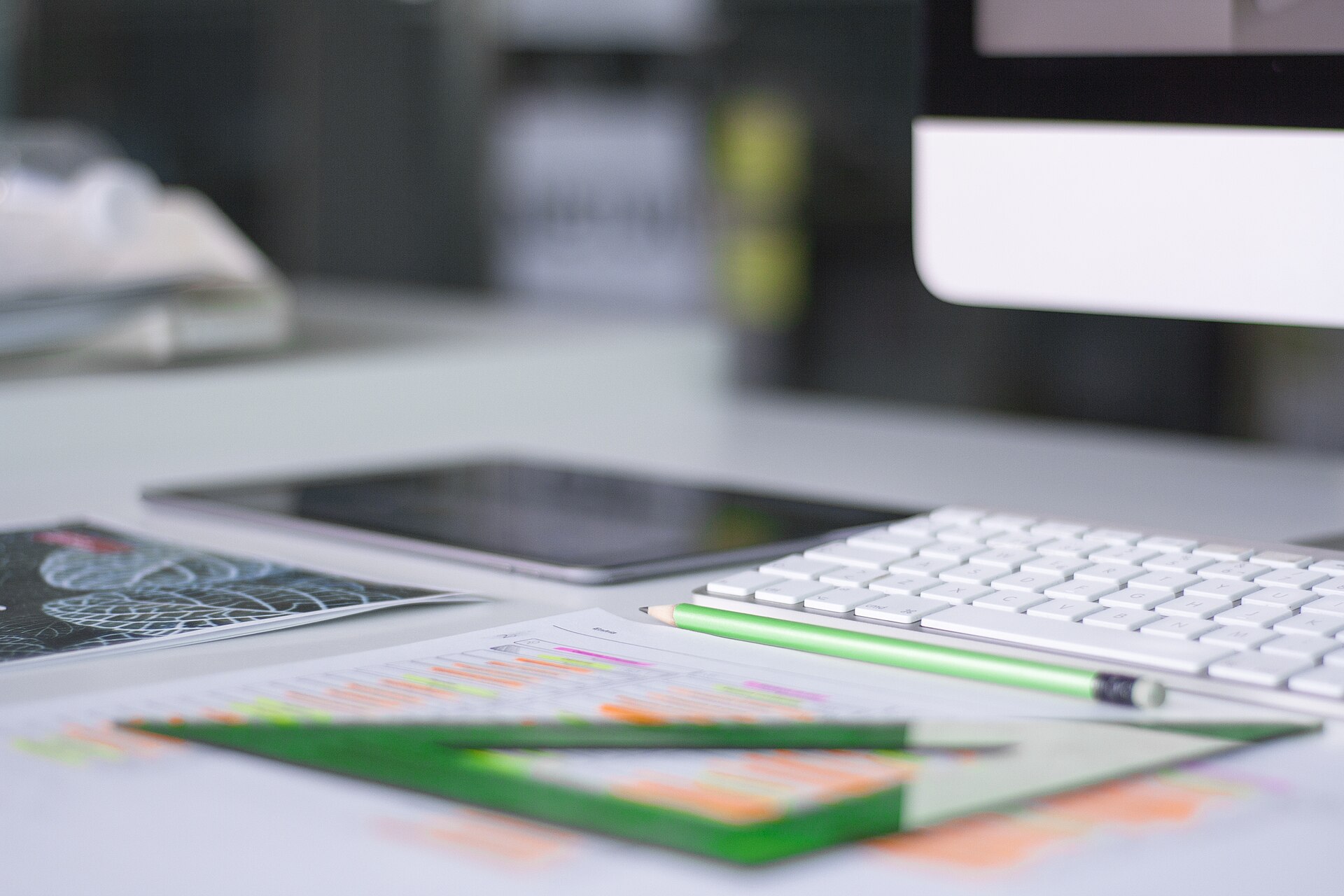 A modern office desk with a keyboard, tablet and business charts